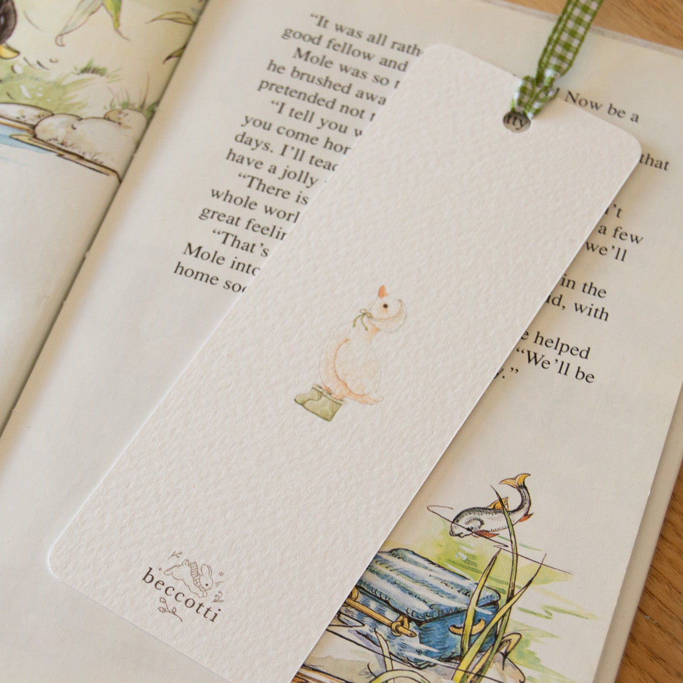 Rainy Duck illustrated bookmark by Beccotti, printed on textured paper with green ribbon, back.