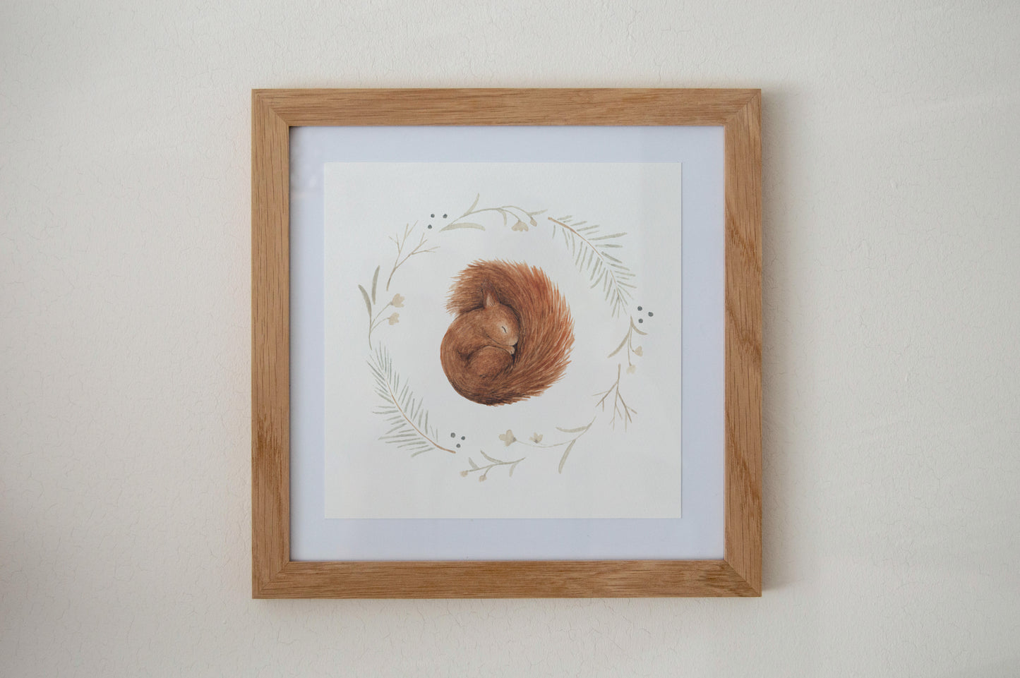 Sleeping Squirrel Art Print hanging on a living room wall, showcasing the woodland animal design