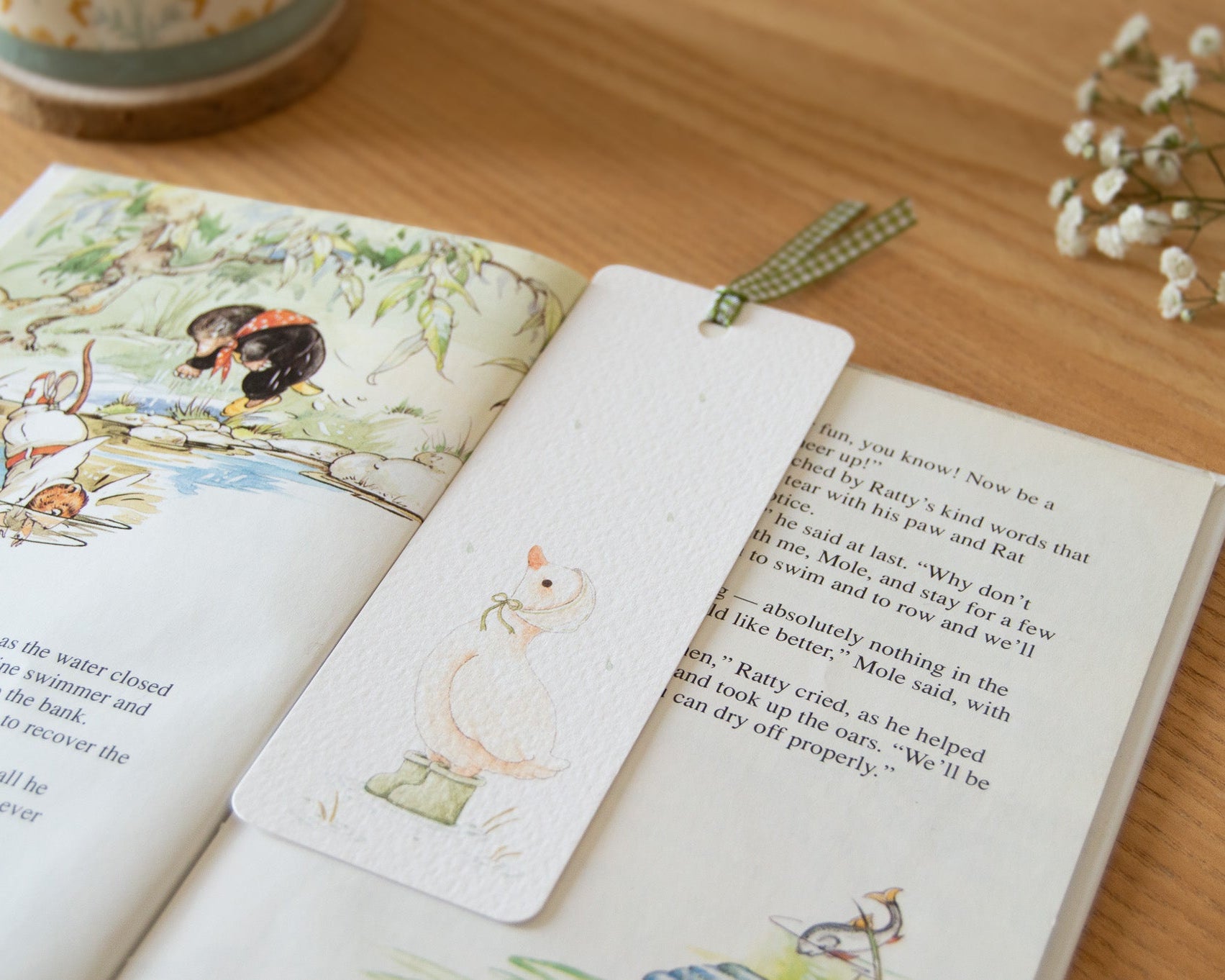 Rainy Duck illustrated bookmark by Beccotti, printed on textured paper with green ribbon.