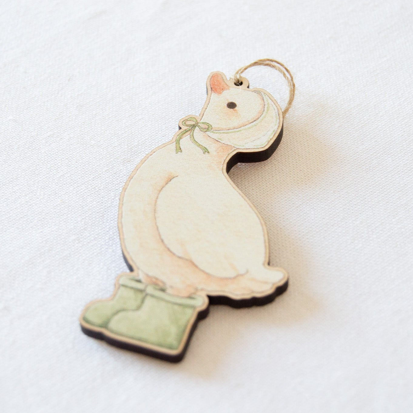 Rainy Duck wooden hanging decoration by Beccotti on cloth at angle.