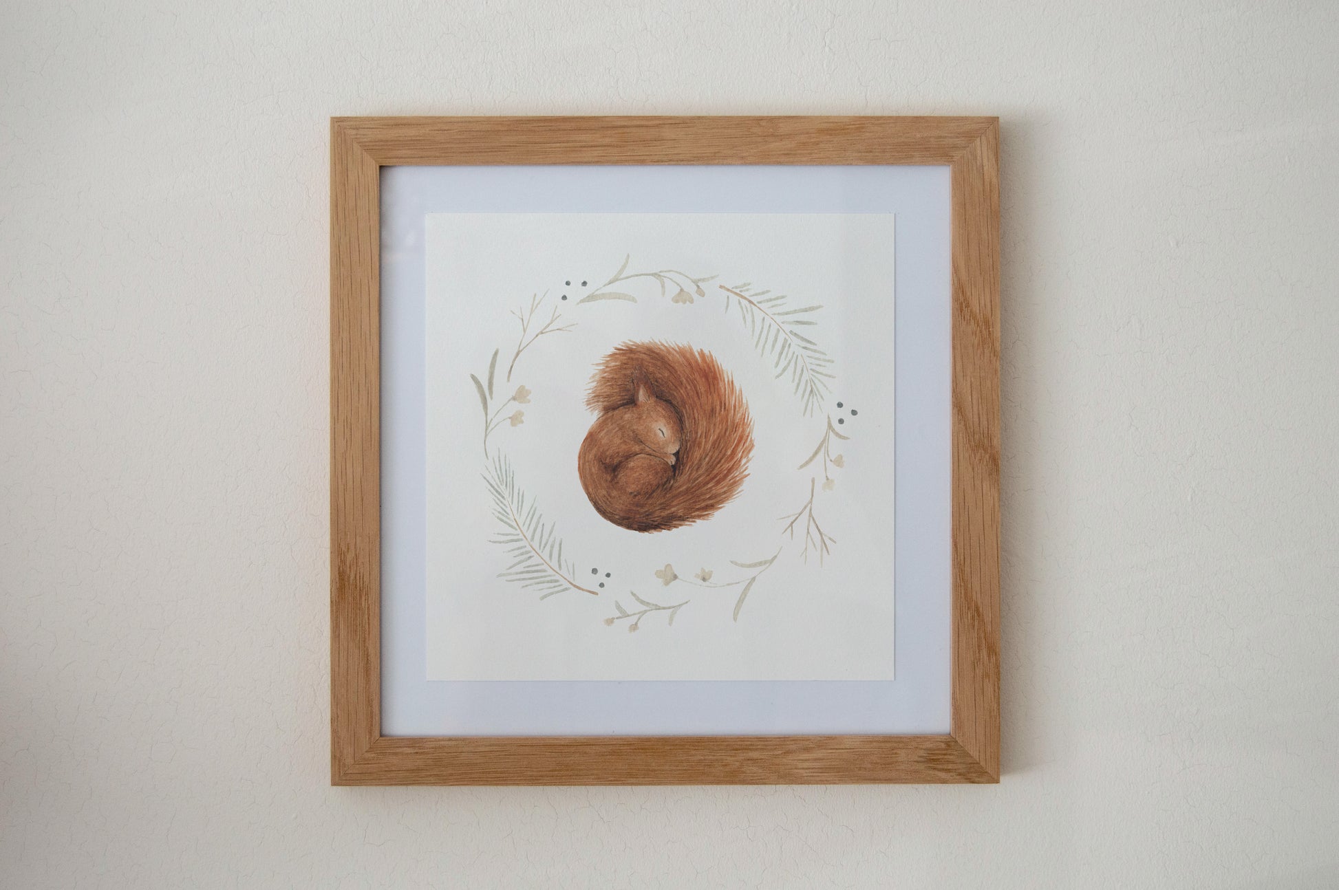 Sleeping Squirrel Art Print hanging on a living room wall, showcasing the woodland animal design